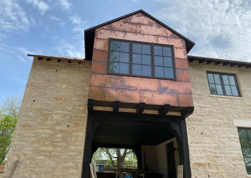 Copper metal panel facade on a stone building for Roof Repair in Tomball