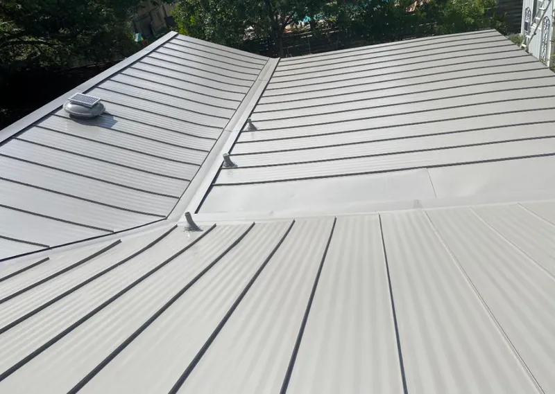 Solar attic fan installed on a metal roof for Roof Ventilation in Tomball